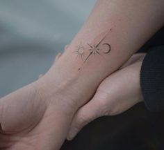 a person holding their hand with a small tattoo on it