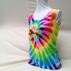 Calliope Spiral Tank Top-Youth This cute little tank top is tie dyed in a brilliant whirl of rainbow colors spiraling from its center, dazzling to the eye and spirit. Evoking the spinning delights of a summer fair. The colors are bold and beautiful. Perfect for wearing to a summer festival or a concert, it is tiedye done right. A quick word about the garment... these run an average misses size, fitted in the torso, in a standard tank styling. It is made of 100% ribbed cotton jersey and kind of stretchy. Sizing corresponds to misses garments, feel free to message if you have questions. If you are looking for something larger please check out the womens tanks that are also available in many of these styles. Dyed with Procion MX fiber reactive dyes. This type of dye chemically bonds with the Tye Dye Tank Tops, Spring Tie Dye Cotton Tank Top, Cotton Tie-dye Tank Top For Festival, Rainbow Tank Top, Spring Tie-dye Hand-dyed Tank Top, Shibori Designs, Baby Tie, Summer Fair, Cotton Tank Top