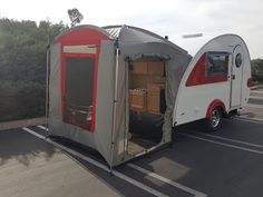 an rv is parked on the side of the road with its door open and it's awning opened