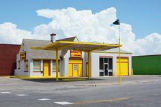 a yellow and white building with a flag on top