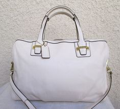 This cool white leather vintage Coach satchel/shoulder bag is in MINT NEW condition.  black piping trim on the edges and brass hardware.  zip top, one large pocket with smaller zip and cellphone pockets inside.  champagne satin interior. Coach White Leather Bag, Chic White Satchel With Metal Hardware, White Shoulder Bag With Metal Hardware For Travel, White Tote Shoulder Bag With Metal Hardware, White Shoulder Bag With Metal Hardware For Everyday, White Leather Satchel With Metal Hardware, White Satchel With Metal Hardware For Travel, Classic White Satchel With Leather Handles, Classic White Satchel For Travel