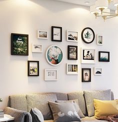 a living room filled with lots of pictures on the wall above a couch and coffee table