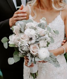 the bride and groom are holding their bouquets