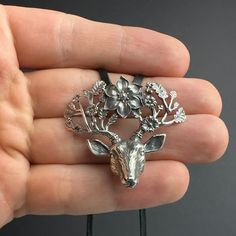 Introducing our Magical Deer Pendant, a unique piece of jewelry that captures the enchantment of the forest. Crafted from 925 sterling silver, this pendant features a magical deer surrounded by flowers, a design that is both intricate and captivating. Measuring 42 x 35 mm and weighing 13.4 grams, this pendant is substantial yet comfortable for everyday wear. It comes with a 65 cm leather cord, adding a rustic touch to the piece and allowing the length to be adjusted to suit your preference. Our Deer Head Necklace, Deer Pendant, Deer Sculpture, Majestic Deer, Surrounded By Flowers, Head Necklace, Gift For Her Birthday, Deer Head, Everyday Outfit