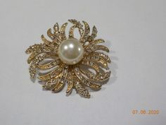 "Vintage RMN (Roman) rhinestone brooch. 2\" diameter with a standard working fastener. Godl tone brooch is loaded with tiny clear rhinestones, all of which are present and intact. One large 12mm faux pearl in the direct center. Absolutely gorgeous and in excellent condition. Signed RMN." Gold Rhinestone Pins For Wedding, Gold Rhinestone Wedding Pins, Gold Wedding Pins With Rhinestones, Gold Round Wedding Pins, Gold Wedding Pins, Hijab Pins, Rhinestone Brooches, Clear Rhinestones, Faux Pearl