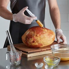 a person in an apron cutting a loaf of bread