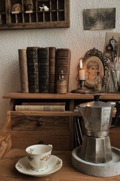 a wooden table topped with a cup and saucer next to a shelf filled with books