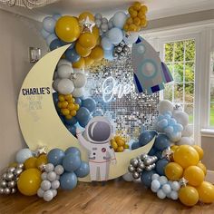 an astronaut balloon arch is decorated with balloons and stars for a space themed birthday party