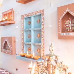 candles are lit in the middle of a room with decorative decorations on the walls and shelves