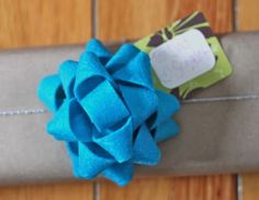 a close up of a wrapped present on a wooden surface with a tag attached to it