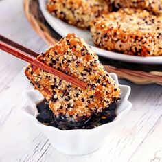 two plates filled with food and chopsticks on top of each other, next to another plate