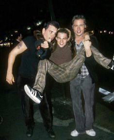 two men and a woman are posing for the camera with their arms around each other