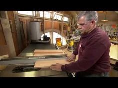 a man standing in front of a machine cutting wood