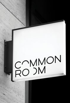 black and white photograph of a sign on the side of a building that says common room