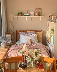 a bed room with a neatly made bed and flowers