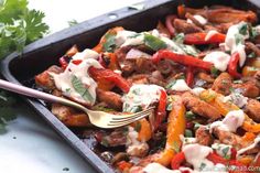 a pan filled with chicken and peppers covered in ranch dressing, garnished with cilantro