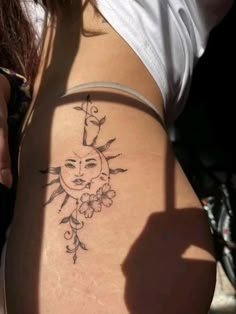 a woman with a sun tattoo on her stomach and the moon behind her back leg