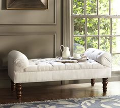 a bed with white linens and pillows on it, in front of a window