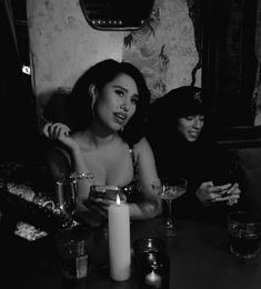 two women sitting at a table with drinks