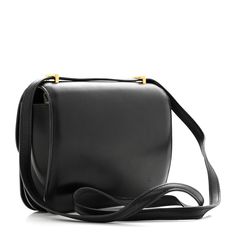 This is an authentic HERMES Evercalf Constance 18 in Black. This is an elegant small bag that is finely crafted of luxurious calfskin leather in black. The bag features a leather cross body shoulder strap, a facing flap, and a gold plated Hermes H logo. The flap opens to a partitioned leather interior with flat pockets. H Logo, H Logos, Leather Cross, Leather Interior, Small Bag, Leather Crossbody, Cross Body, Calf Skin, Shoulder Strap