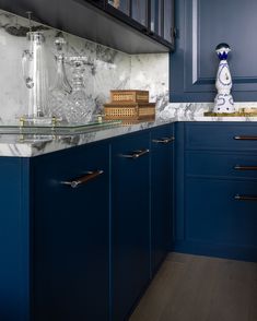 a kitchen with blue cabinets and marble counter tops