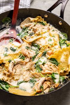 a skillet filled with pasta and spinach