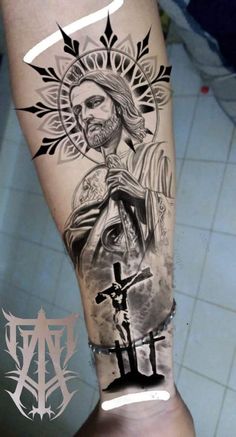 a man's leg with a tattoo on it and an image of jesus holding the cross