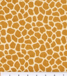 a giraffe print fabric with a ruler in front of the image, it is yellow