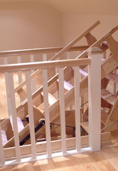 an unfinished stair case with wooden railings and wood flooring