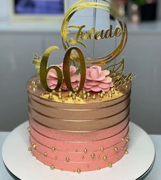 a pink and gold cake sitting on top of a white plate