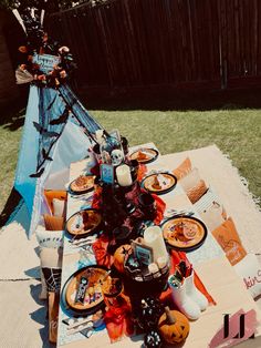 an outdoor table set up for halloween dinner