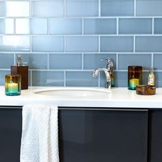 a bathroom sink with two soap dispensers next to it