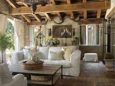 a living room filled with white furniture and lots of wood planks on the ceiling