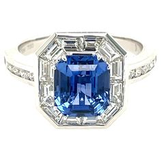 This stunning Cocktail Ring features a beautiful 3.05 Carat Emerald Cut Sapphire with a Diamond Halo of Baguette White Diamonds, that sits on a Diamond Shank. This Ring is set in 18K White Gold. Total Diamond Weight = 1.01 carats. Ring Size is 6 1/2. Vintage Sapphire Ring, Diamond Sapphire Engagement Ring, Sapphire Diamond Engagement, Tanzanite Diamond Ring, Sapphire And Diamond Ring, Purple Sapphire, Diamond Cocktail Rings, Modern Ring, Sapphire Stone