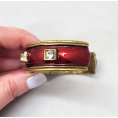 This is part of Chairish’s Costume Jewelry assortment.  1980s goldtone red enamel and round clear rhinestone slip on cuff bracelet. Marked "YOSCA©." Measures: 3/4 inches tall by 2 3/4 inches wide and 2 1/8 inches deep. Opening measures: 1 1/2 inches across. Interior circumference is about 6 1/2 inches. Condition: Exterior is in very good condition; interior has some darkening/discoloration. The matching clip earrings are also available for purchase. Elegant Red Metal Cuff Bracelet, Red Metal Cuff Bracelet Bangle, Red Metal Bangle Cuff Bracelet, Red Metal Cuff Bracelet, Vintage Red Metal Bangle, Chanel Cuff Bracelet, Blue Cuff Bracelet, Chanel Cuff, Black Cuff Bracelet