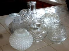 several glass vases sitting on a counter top