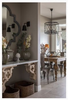 a dining room table with chairs and vases on it's shelf next to a mirror