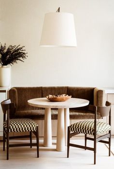 a white table and two chairs in a room with a light hanging from the ceiling