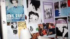 a room with posters on the wall and a lamp