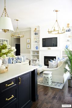 a living room filled with furniture and a flat screen tv mounted on the wall above a fireplace