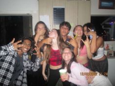 a group of young people standing next to each other posing for a photo with their hands in the air