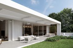 an artist's rendering of a modern house with white furniture and large glass doors