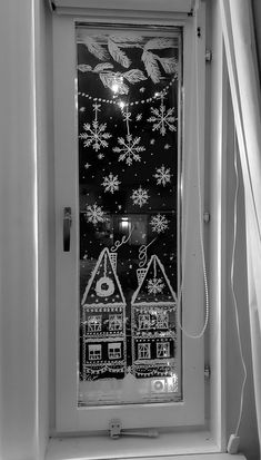 a black and white photo of a window with snowflakes on it