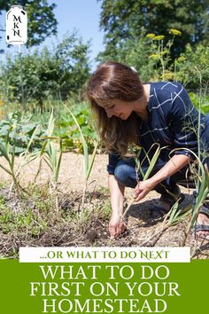 a woman kneeling down in the middle of a field with her hands on some plants