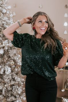 Spread more cheer in our Half Puff Sleeve Sequin Top in a festive green. This stylish top features eye-catching sequins and playful half puff sleeves, adding a touch of glamour to your winter and festive ensembles. Whether you're dressing up for a holiday party or adding flair to a casual look, the More Cheer Sequin Top ensures a statement of style. Green sequins detailing Lining Peek-hole + button closure Half balloon sleeve 100% polyester Imported Model Specs: Karli is wearing a size small in Comfy Christmas Outfits, Jollywood Nights, Half Puff Sleeve, Holiday Party Outfit Casual, Christmas Outfit Aesthetic, Green Velvet Top, Style Wide Leg Jeans, Bride Top, Casual Party Outfit