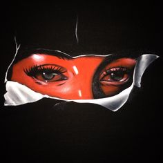 a woman's face is seen through the hole in her black hoodie with red and white eyeliners