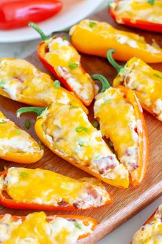 several stuffed peppers on a wooden cutting board