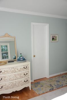 a white dresser and mirror in a room