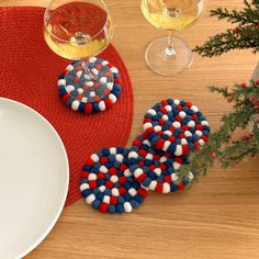 two red, white and blue cookies sitting on top of a table next to wine glasses