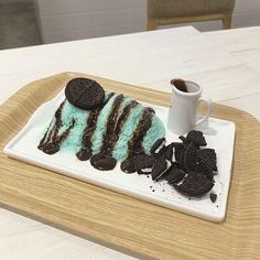 a plate that has some cookies and green cake on it with oreo cookies next to it